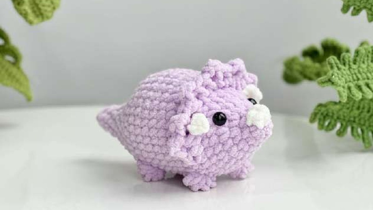 Purple no-sew crochet triceratops with a scalloped frill and three white horns